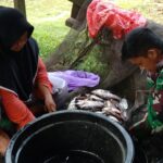 Sarana Perkuat Silaturahmi, Anggota Satgas TMMD Reguler ke-116 Bersihkan Ikan Untuk Di Masak Bersama Warga