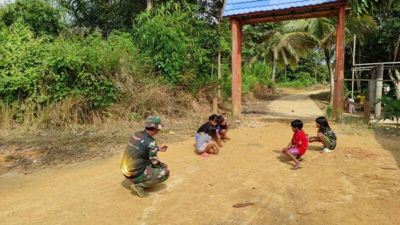 Manfaatkan Waktu Luang, Satgas TMMD ke 117 Bermain Kelereng Bersama Anak-Anak