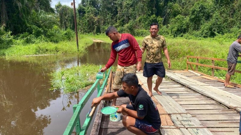 Satgas TMMD Reg ke-123 Bantu Warga cat Pagar Jembatan Di Desa Tumbang Panggo