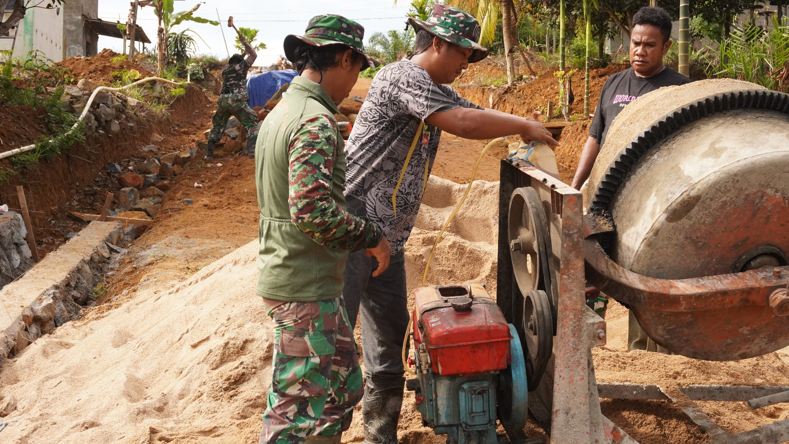 Sigap Anggota Satgas TMMD ke-127 Kodim 1015/Sampit Perbaiki Mesin Molen Yang Rusak