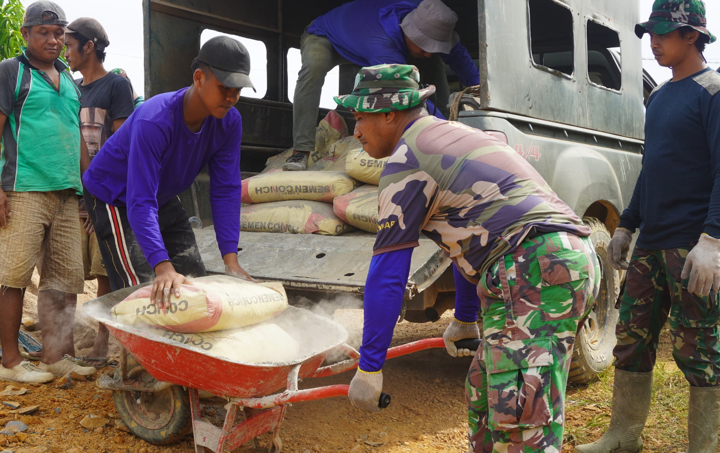 Anggota Satgas TMMD Reguler ke-127 Kodim 1015/Sampit Turunkan Semen Untuk Pembuatan Siring Badan Jalan