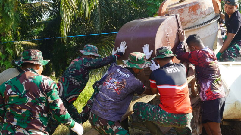 Satgas TMMD Reg Ke-127 Bekerjasama Untuk Memindahkan Mesin Molen