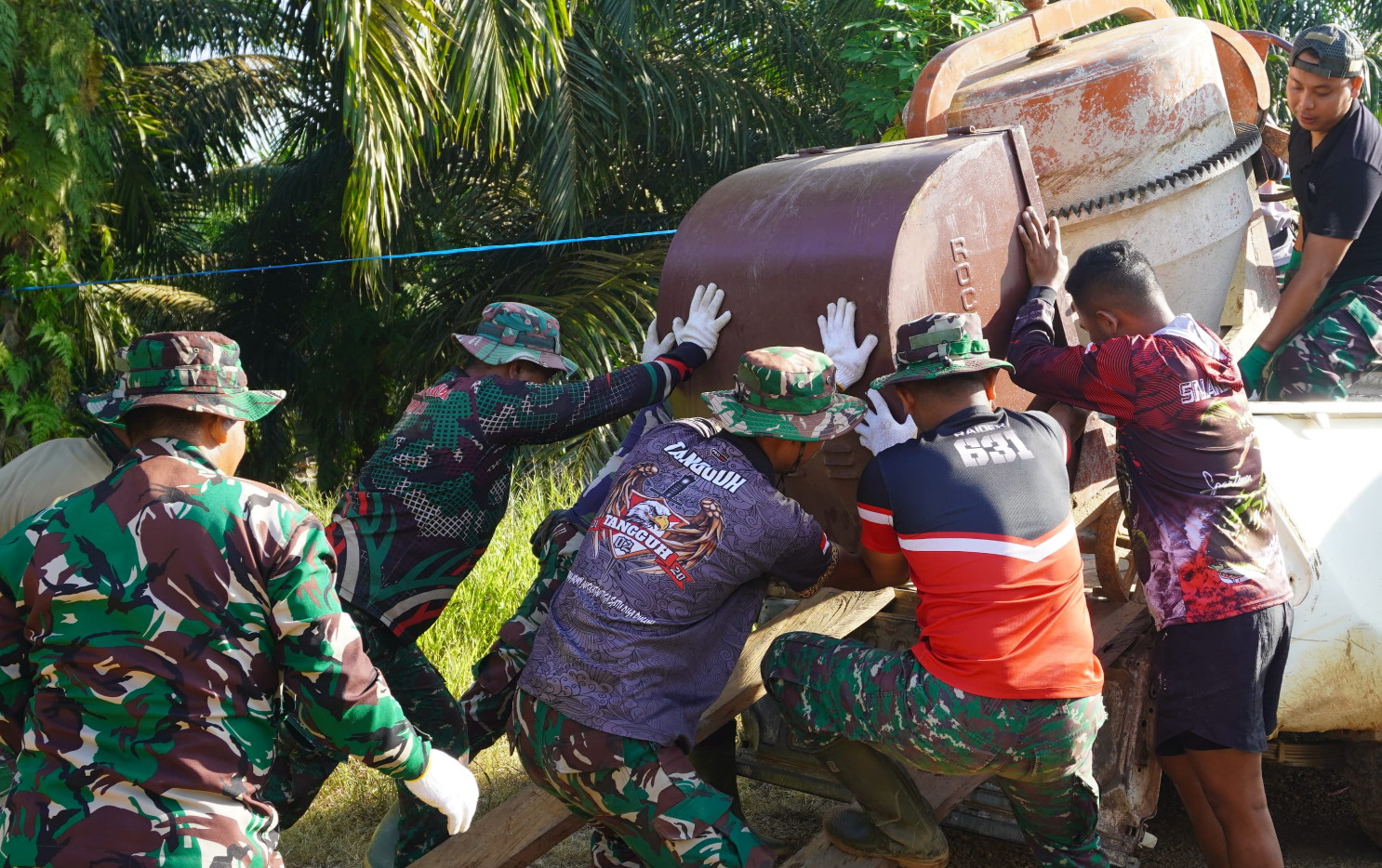 Satgas TMMD Reg Ke-127 Bekerjasama Untuk Memindahkan Mesin Molen