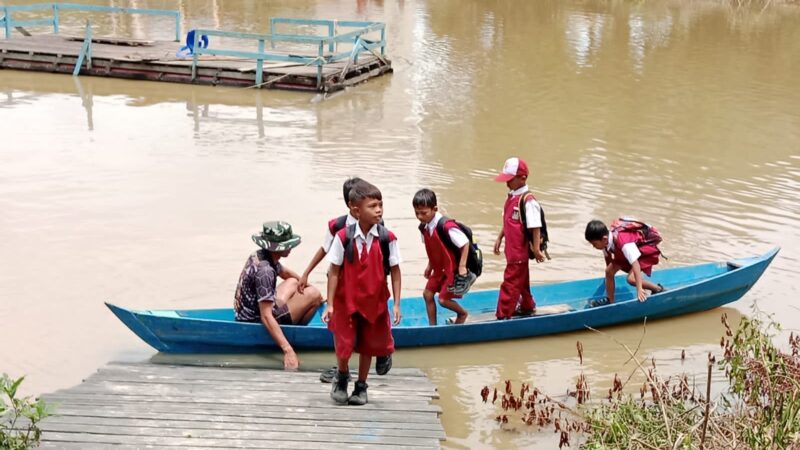 Jembatan Garuda Masih Tahap Pembagunan, Babinsa Koramil 1015-07/Parenggean Bantu Antar Jemput Anak Sekolah Mengunakan Perahu