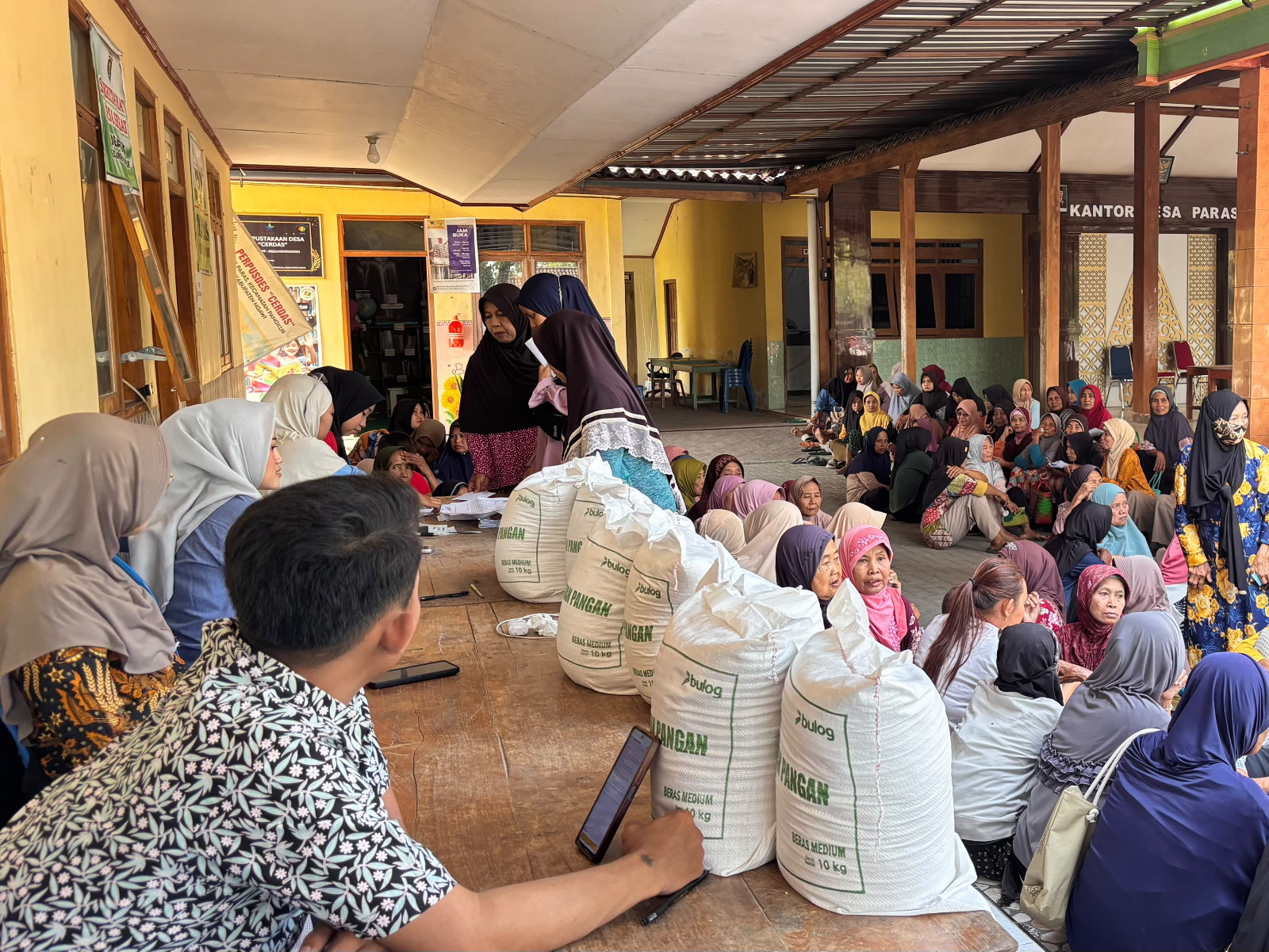 “Pegawai BULOG Turun Langsung Serahkan Bantuan Beras di Desa Paras Kecamatan Pangkur Kabupaten Ngawi”.